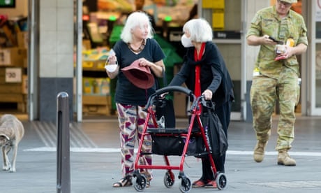 Two women, including one with a walker, chat outside a supermarket in Sydney