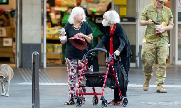 Two women, including one with a walker, chat outside a supermarket in Sydney