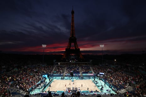 A view of the Eiffel tower at dusk during a volleyball match between Kristen Nuss and Taryn Kloth of the US and Heather Bansley and Sophie Bukovec of Canada.