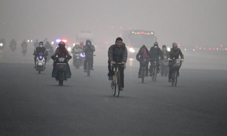 People cycle in heavy smog in Beijing.