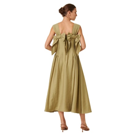 This a back view of the model wearing sage midi dress. Each shoulder strap meets the shoulder blade with a dramatic bow.