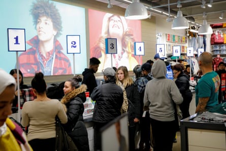 Clothing store worker helps client on black friday, showing new