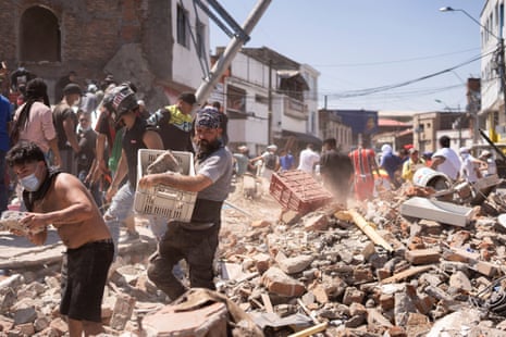 Residents dig through the debris of a collapsed building after an earthquake, in Cali, Colombia August 10, 2026.