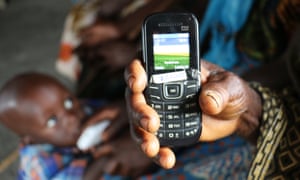 A woman holding a basic phone