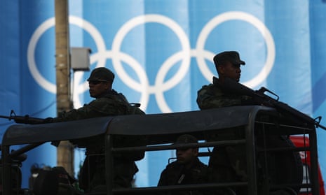 Brazilian soldiers keep watch in front of Olympic rings at the beach volleyball venue ahead of the arrival of the Olympic torch relay in Copacabana on Thursday.