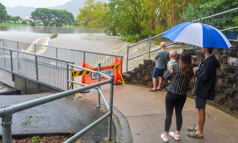 Local residents watch water flow over Aplin’s weir in the Townsville suburb of Mundingburra amid the Queensland floods