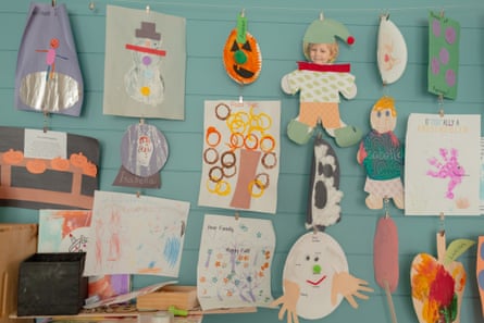 children’s art decorates the blue wall of a home