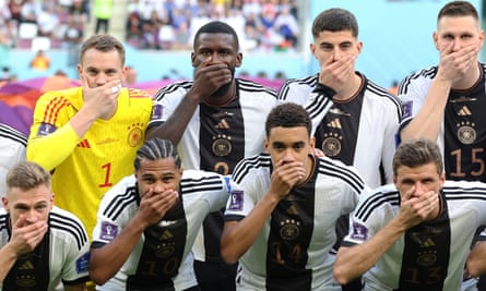 Les joueurs allemands posent les mains sur la bouche avant le match de la Coupe du monde avec le Japon après l'interdiction du brassard arc-en-ciel