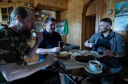 Mitrofan Soldatenko in the prefab by the church eating with Alex who occasionally attends and works at the Russian base