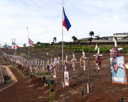 Flags, crosses and photos lined up along the side of the road