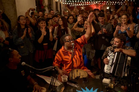 A drummer performs on the street as a crowd watches