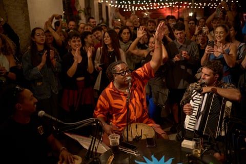 Un baterista toca en la calle mientras una multitud observa.