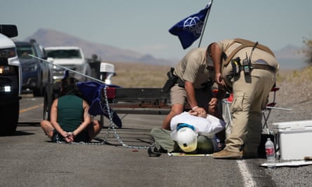 officers hold down protester while another sits handcuffed