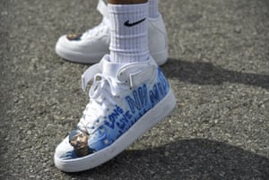 A fan wears shoes in tribute to Nipsey Hussle at the late rapper’s memorial service.