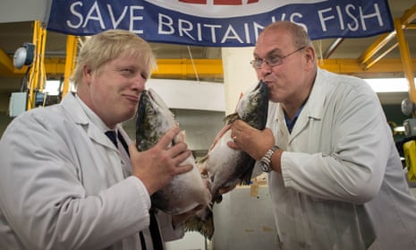Boris Johnson kisses a wild salmon as he is shown around Billingsgate Fish Market in London with porter Greg Essex
