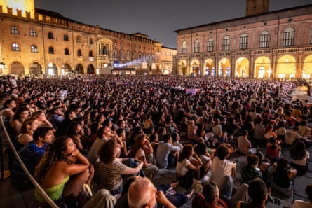 Young people packed into the square watching a film