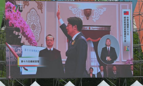 A giant screen outside the Presidential Office shows a live feed of Taiwan's President-elect Lai Ching-te (C) taking his oath during the inauguration ceremony at the Presidential Office Building in Taipei