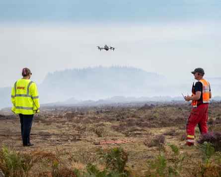 Darren Cleaves wearing orange hi-vis operating a drone