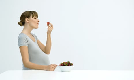 Pregnant woman eating strawberry