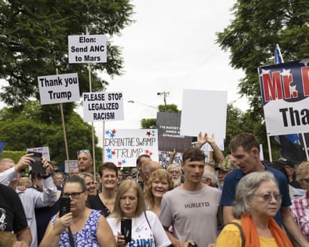 A crowd of people marching with homemade banners thanking Donald Trump