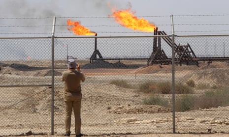 A journalist takes pictures of the West Qurna-1 oilfield, which is operated by ExxonMobil near Basra, Iraq.