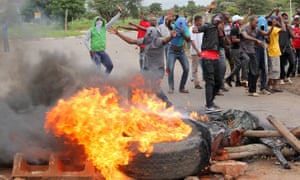 Protesters stand behind a burning barricade during protests earlier this month.