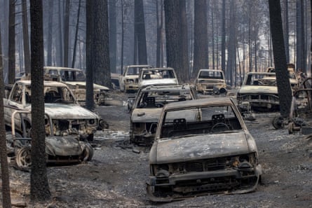 Scorched vehicles destroyed by the Caldor fire rest on Evergreen Drive in Grizzly Flats, California.