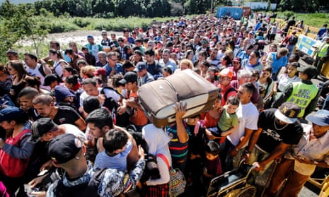 People queue to cross the bridge from San Antonio del Tachira in Venezuela to Cucuta, in Colombia, to buy goods due to supplies shortage in their country