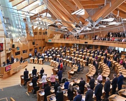MSPs join in the national two-minute silence on the 80th anniversary of VE Day, before first minister’s questions in the Scottish parliament, in May 2025