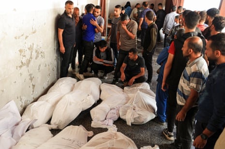 Mourners next to the bodies of Palestinian people killed in Israeli strikes, during a funeral in Gaza City.