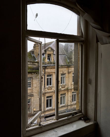 The Victorian building across from the former Wildings site is seen through a dark window space