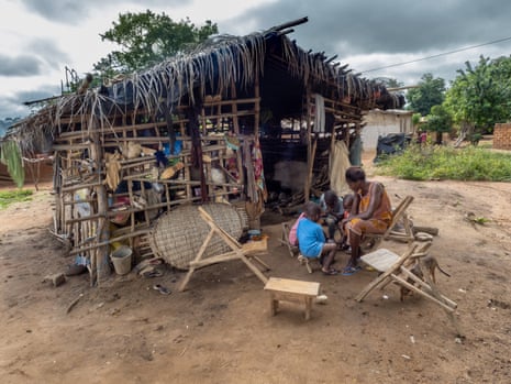 Kouame Aya Marie with two of her grandchildren outside their hut in their Ivory coast village.