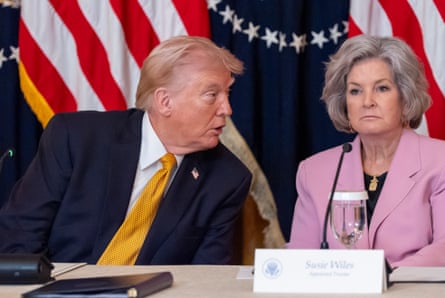 Donald Trump speaks to White House chief of staff, Susie Wiles in the White House in front of a US flag