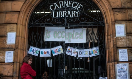 A protester stands outside Carnegie library in South London during its occupation in protest against cuts