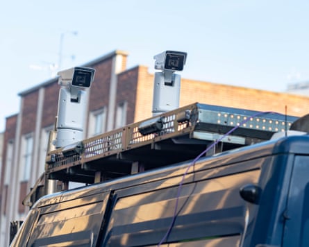 Two cameras mounted on top of a van.