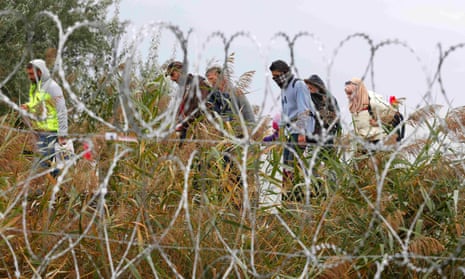 Refugees pass a barbed wire fence in Röszke, Hungary.