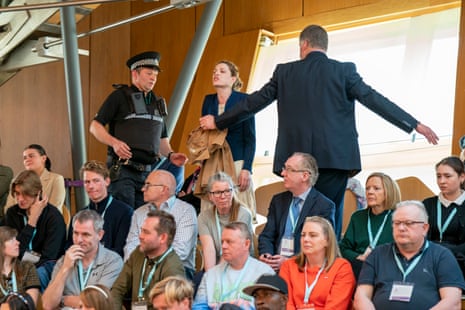 A protester being removed from the public gallery during FMQs at Holyrood today. Climate activists have been regularly disrupting FMQs for weeks now.
