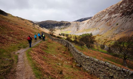 Walkers on the path above Glenriddding Beck heading for Red Tarn in the Lake District national park.