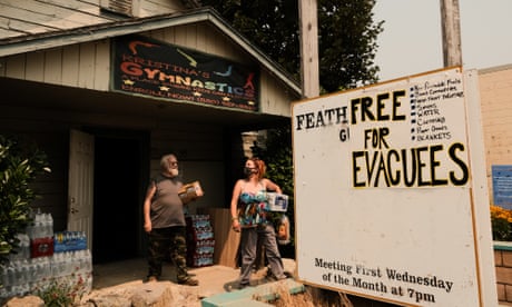 Dixie Fire Continues To Burn Through Northern California Forcing Evacuations<br>QUINCY, CA - AUGUST 08: Evacuated from their homes in Plumas County, Paula Perozzi and Dale Evans walk out of a grange hall situated along Highway 70 with supplies provided by volunteers on August 8, 2021 in Quincy, California. The Dixie Fire, which has incinerated more than 463,000 acres, is the second largest recorded wildfire in state history and remains only 21 percent contained. (Photo by David Odisho/Getty Images)