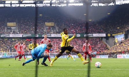 Youssouf Moukoko rodea al portero para marcar el gol del Dortmund.