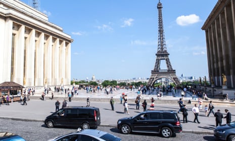 Large cars in front of the Eiffel Tower