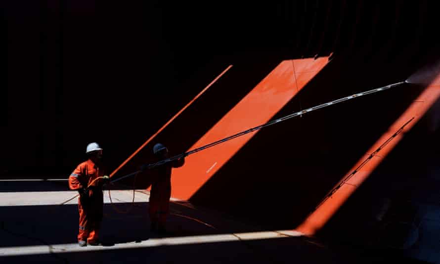 Two crew members in the hold of an empty cargo ship