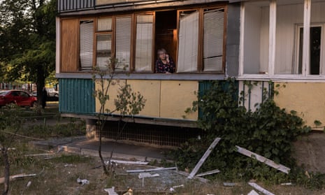 A woman stands on a balcony of a residential building that was damaged during a Russian missile attack on 1 June