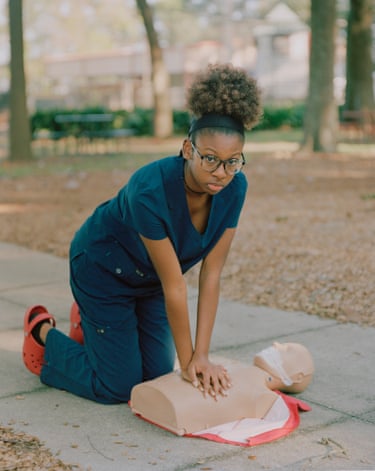 girl kneeling over resuscitation training head and shoulders
