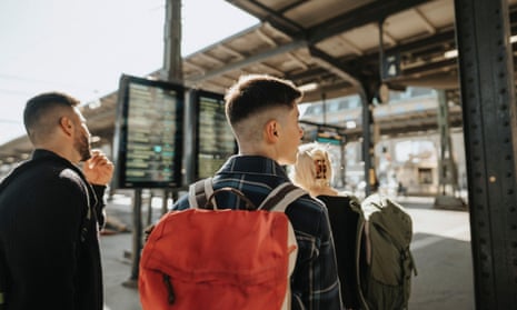 Boy wearing a backpack, waiting at a train station