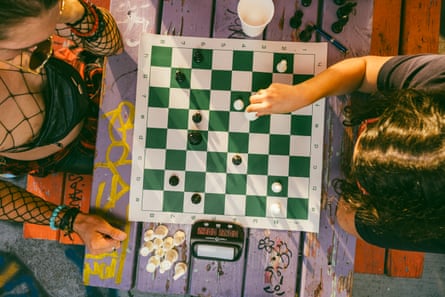 view from above of two people playing chess on a purple table