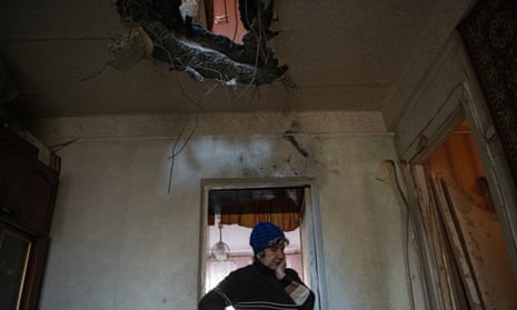 A woman stands inside her apartment, which was damaged by shelling, in Donetsk.