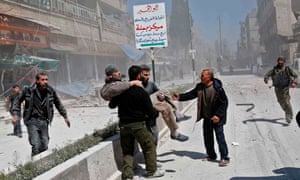 Syrians carry an injured man following a reported government air strike on the rebel-controlled town of Hamouria