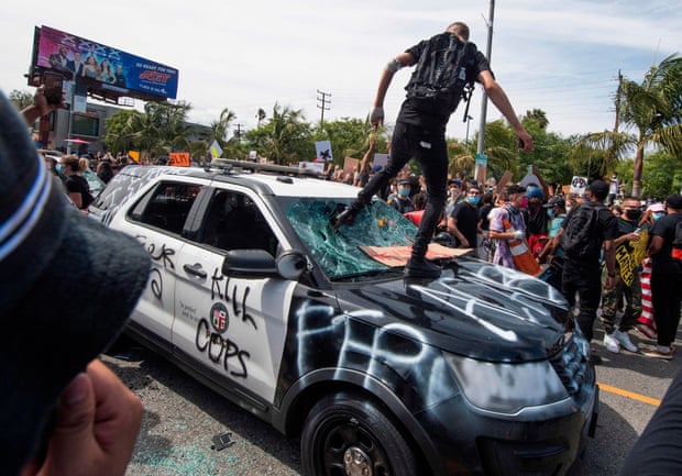 Demonstrators smash a police vehicle in the Fairfax District, in Los Angeles, California