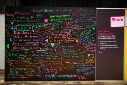 Eine schwarze Wand mit positiven Gesundheitsbotschaften in Neonfarben
